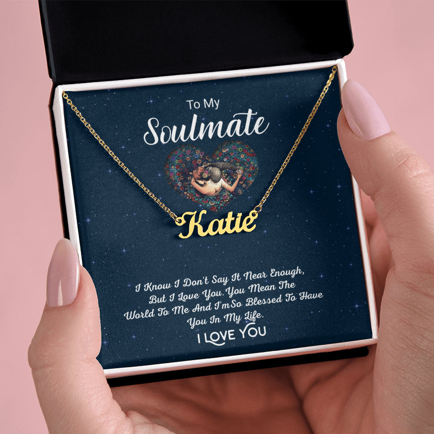 Hands holding the To My Soulmate personalized gold name necklace in an open black gift box against a pink background